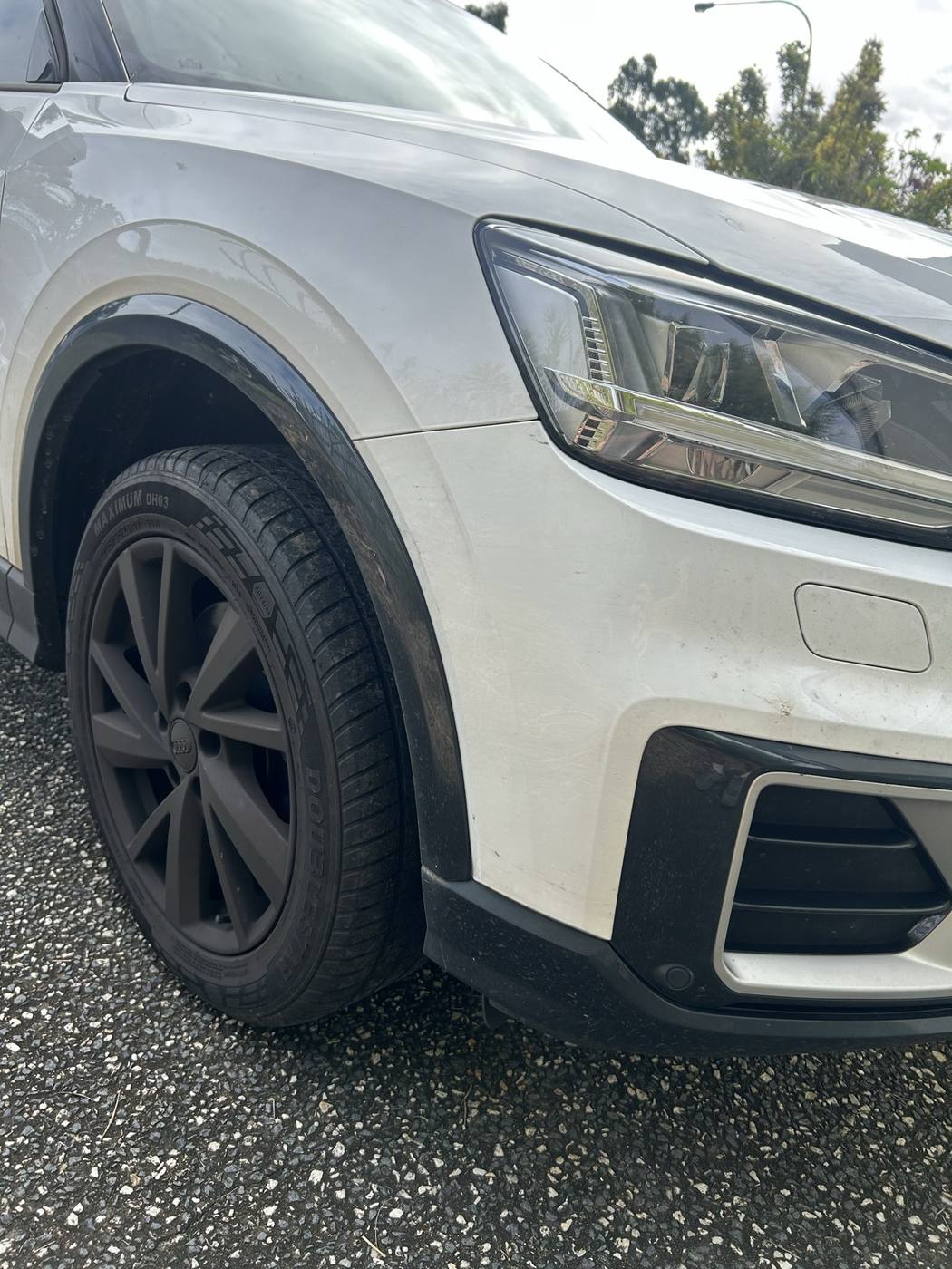 Audi Q2 front bumper and wheel before detailing — dull and dirty