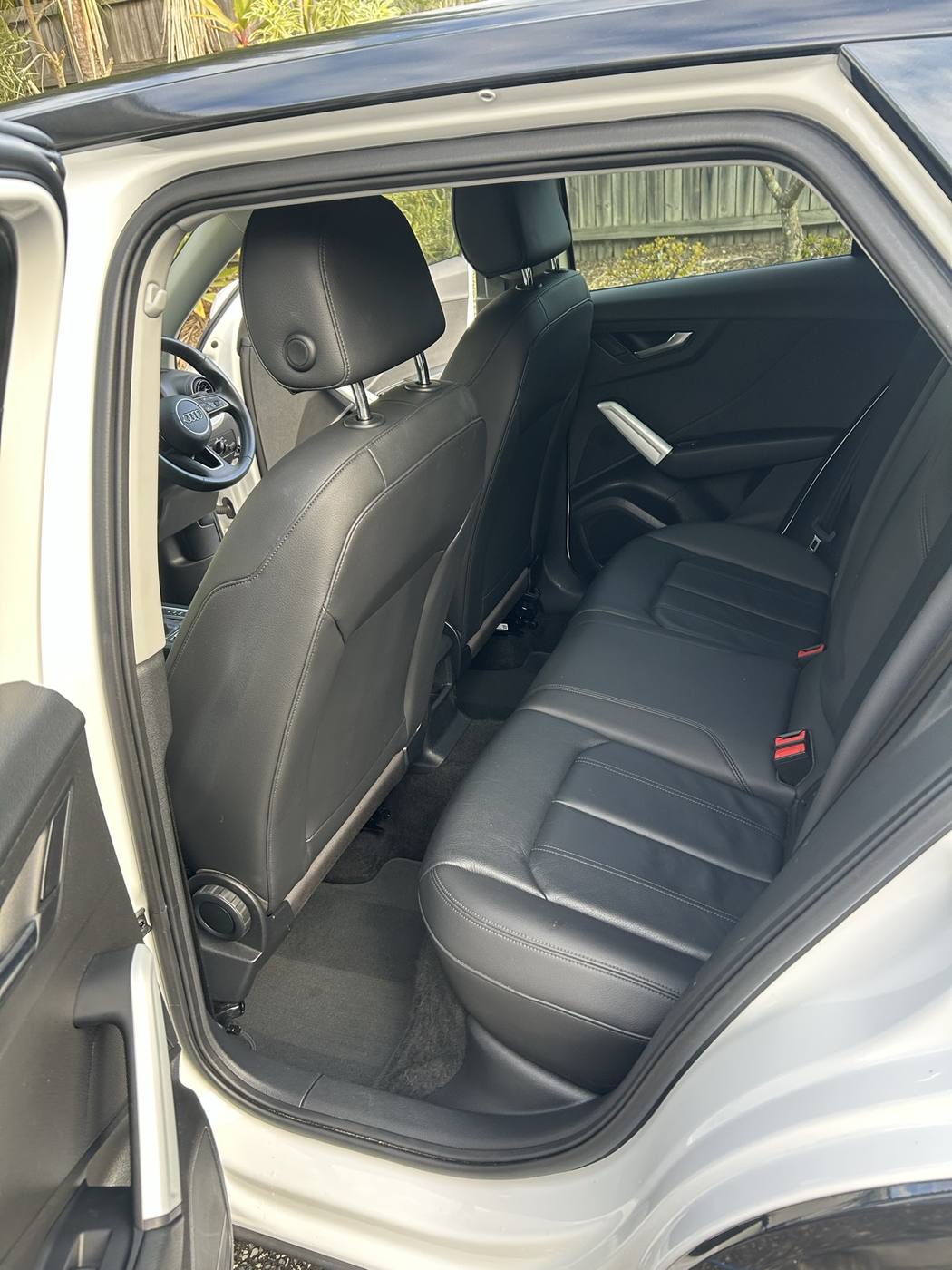 Rear seats and floor after detailing — clean leather and fresh carpet