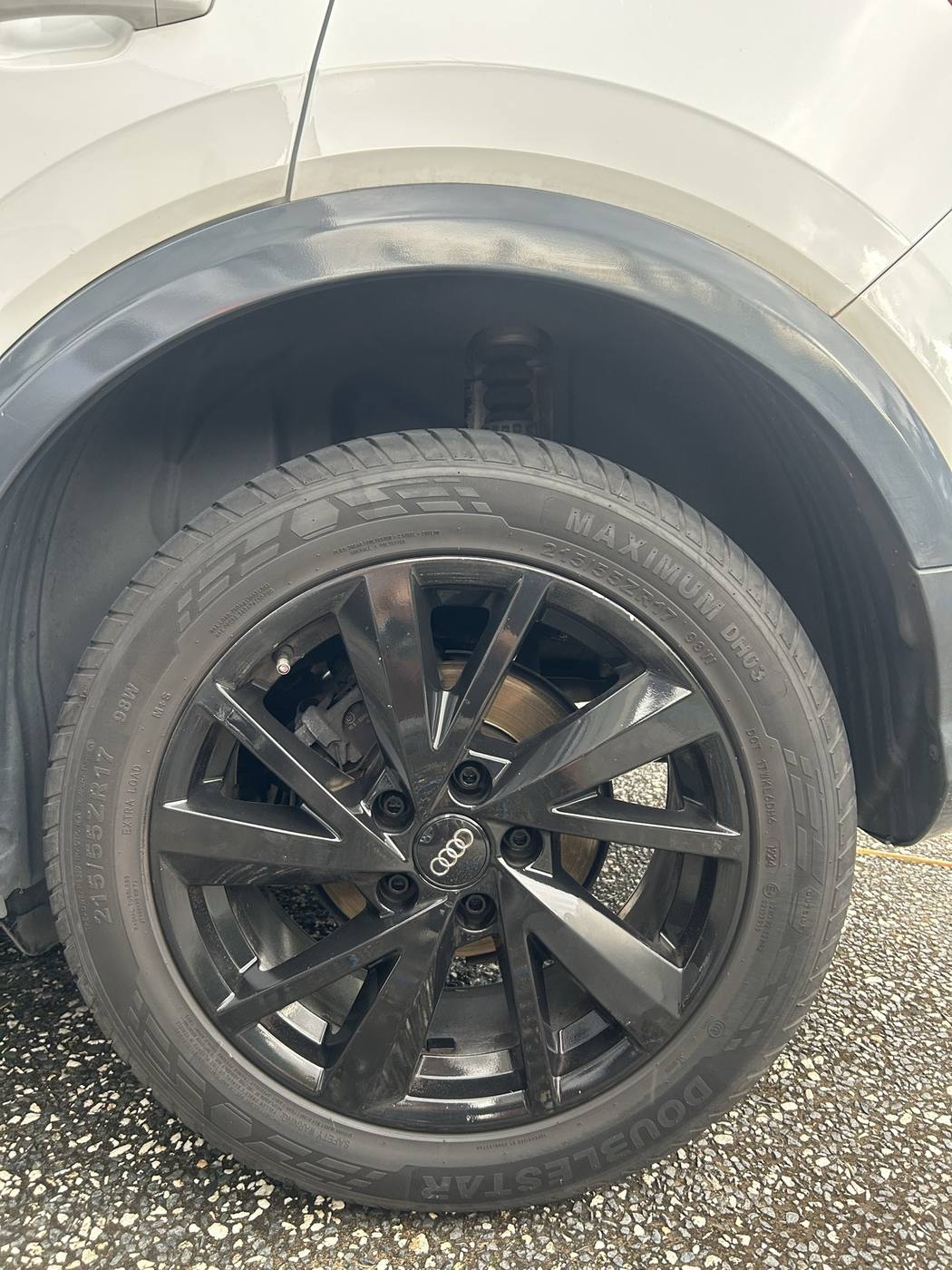 Alloy wheel after detailing — deep gloss black finish and dressed tyre