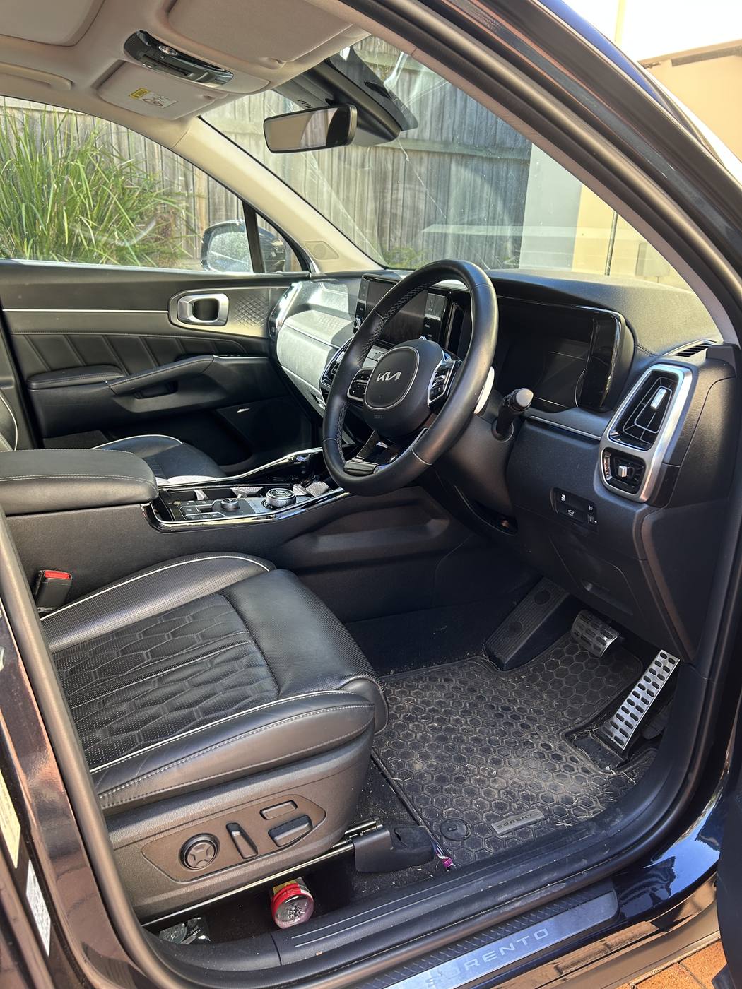 Kia Sorento driver cabin before detailing — debris through the footwell