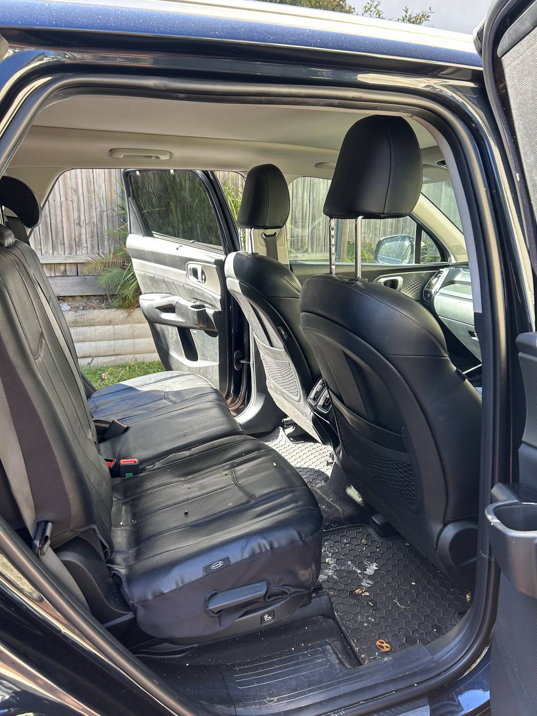 Kia Sorento rear seats before detailing — dirt through the floor mats