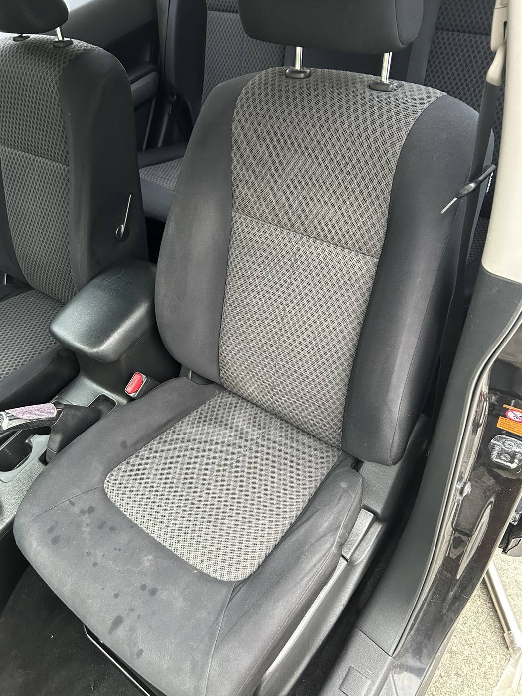 Cloth front seat before detailing — stained and marked fabric